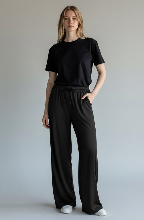 Satinly satijnen wide-leg broek zwart - model vooraanzicht studio grijs